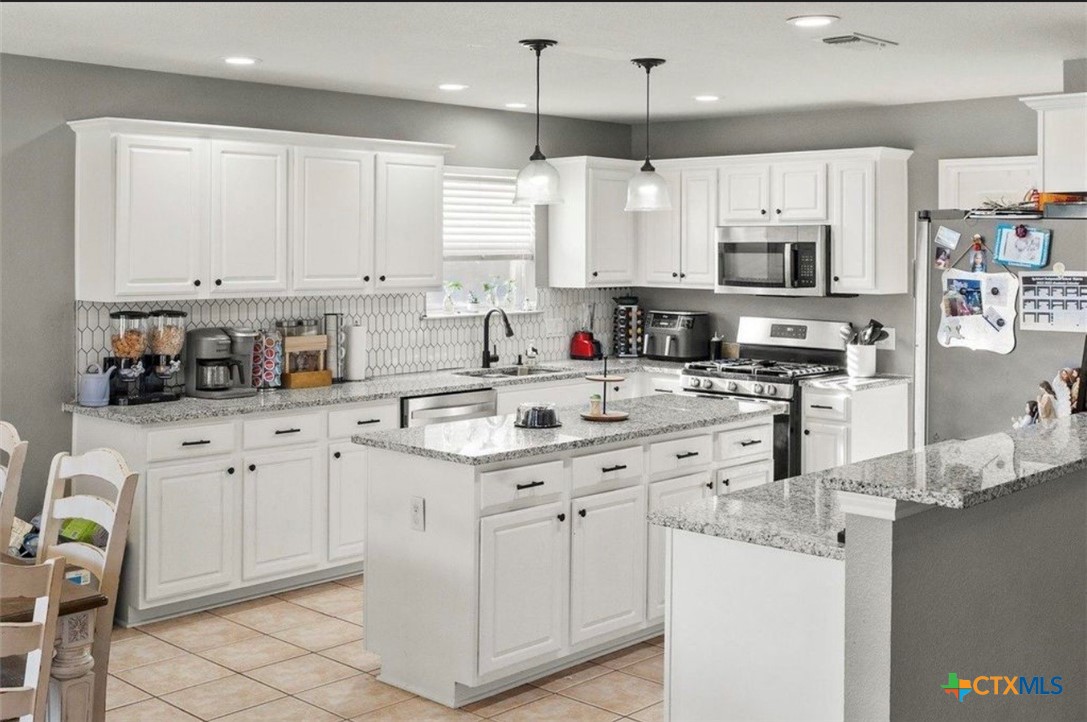 512 South Mockingbird Lane Lockhart, TX 78644 - Photo 7 of 22 a kitchen with cabinets appliances a sink and a counter top space
