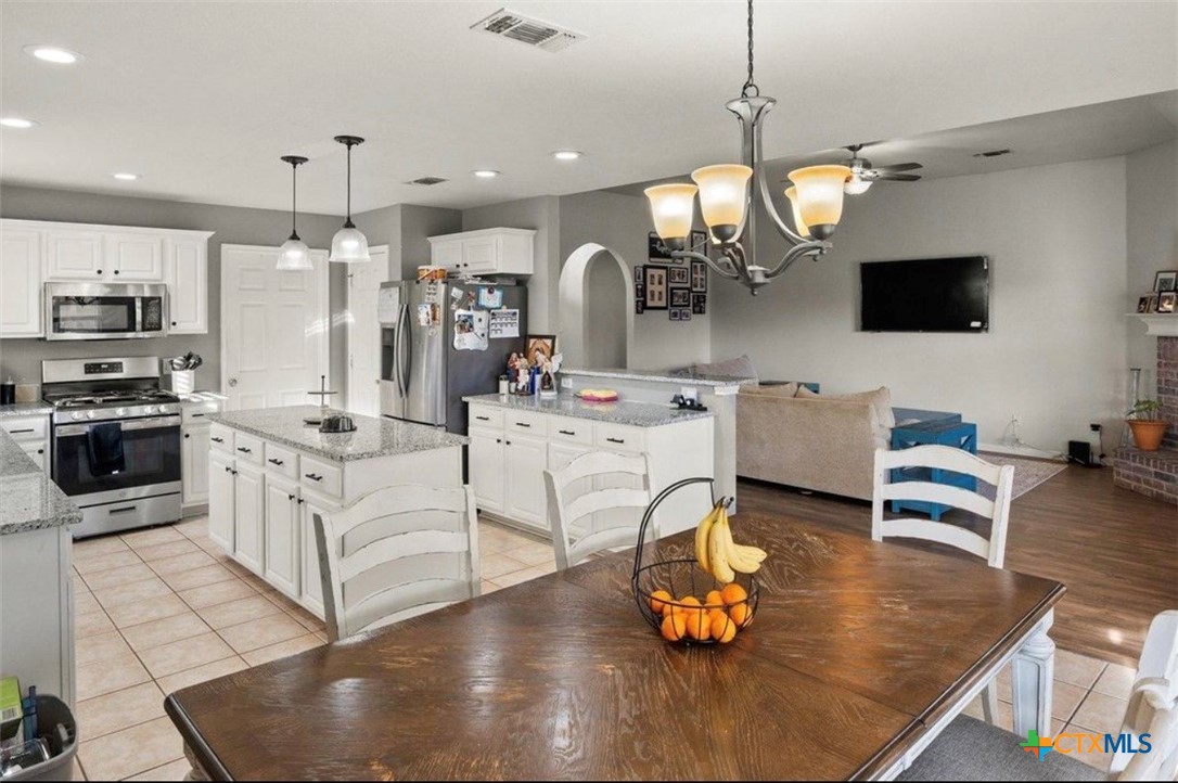 512 South Mockingbird Lane Lockhart, TX 78644 - Photo 8 of 22 a kitchen with stainless steel appliances granite countertop a stove refrigerator and cabinets
