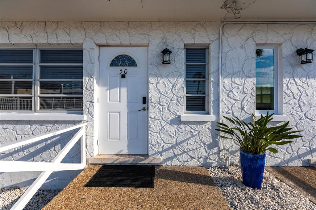 6020 Midnight Pass Road, Unit 50 Sarasota, FL 34242 - Photo 1 of 22 a vase of flowers sitting on a table in front of a window