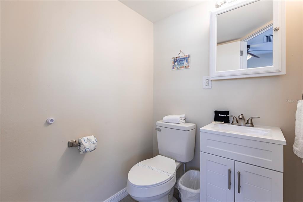 6020 Midnight Pass Road, Unit 50 Sarasota, FL 34242 - Photo 16 of 22 a white toilet sitting next to a white sink and vanity