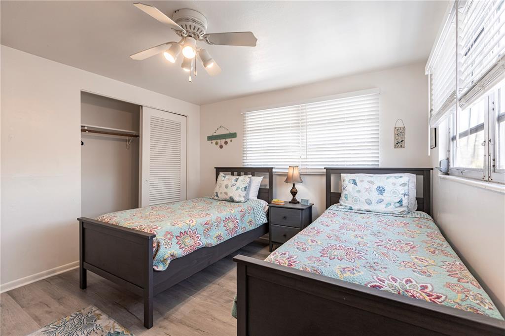 6020 Midnight Pass Road, Unit 50 Sarasota, FL 34242 - Photo 18 of 22 a bedroom with two beds and a chandelier