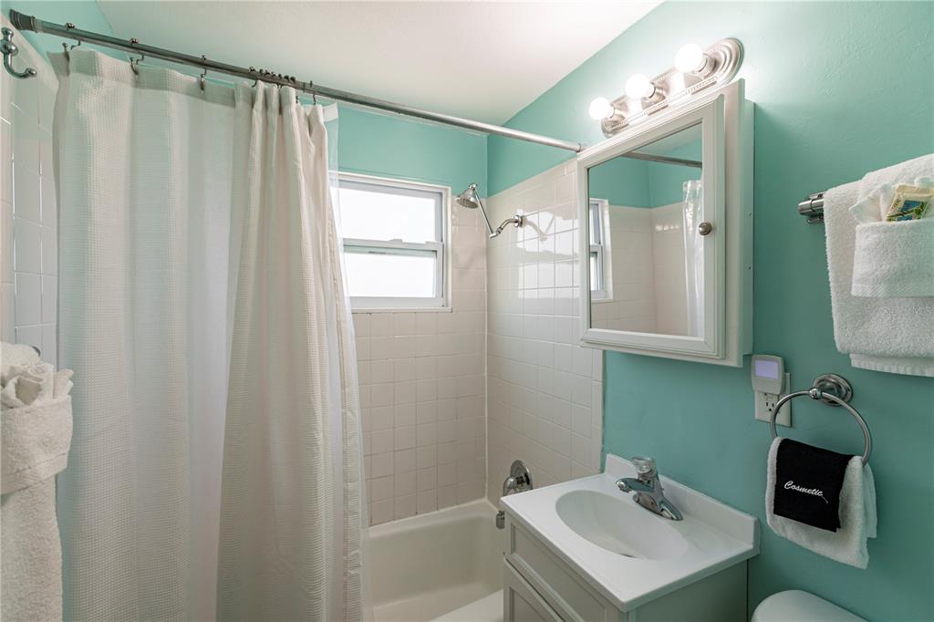 6020 Midnight Pass Road, Unit 50 Sarasota, FL 34242 - Photo 21 of 22 a bathroom with a sink mirror and a shower