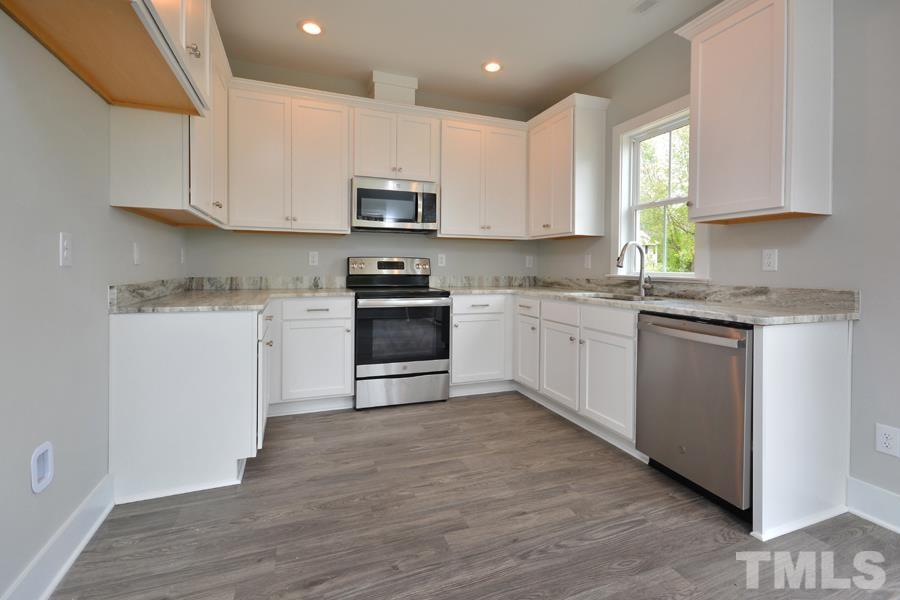 100 Southern Middle School Road Roxboro, NC 27573 - Photo 9 of 28 a kitchen with stainless steel appliances granite countertop a stove top oven a sink and white cabinets