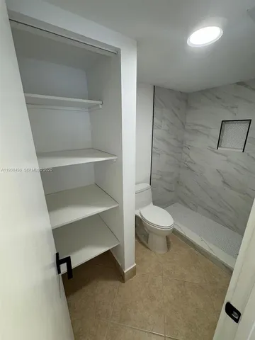a bathroom with a toilet and a shower