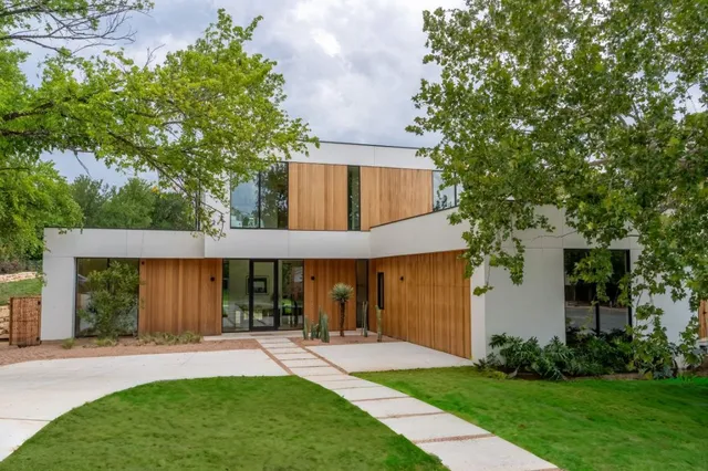 front view of a house with a yard and a large tree