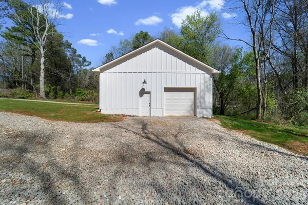 a view of a house with backyard and trees