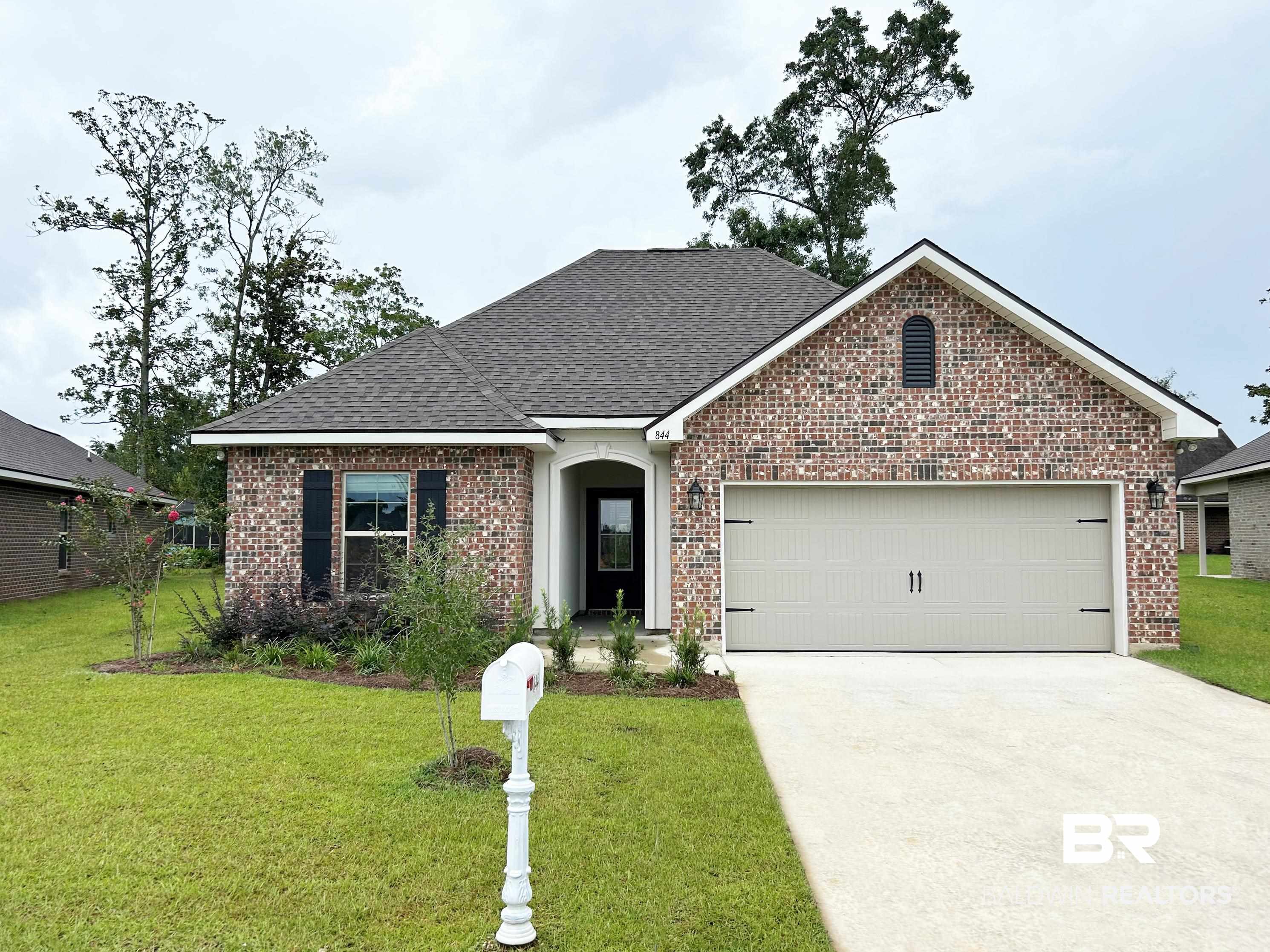 View of front of house with a garage and a front yard