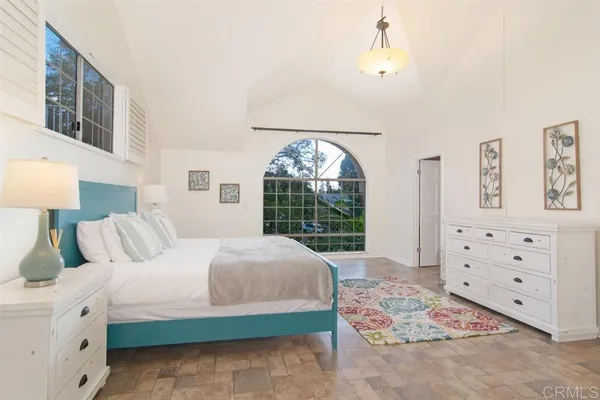 a bedroom with a large bed and a window