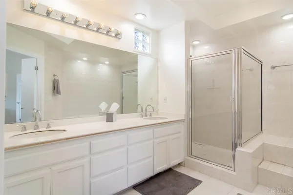 a bathroom with a shower sink and mirror