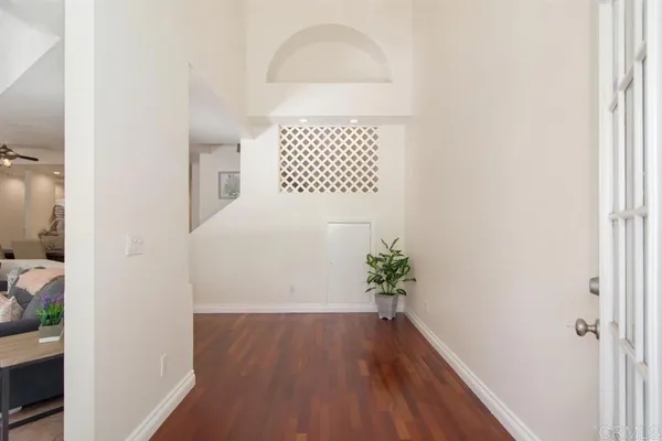 a view of a hallway with wooden floor and a potted plant