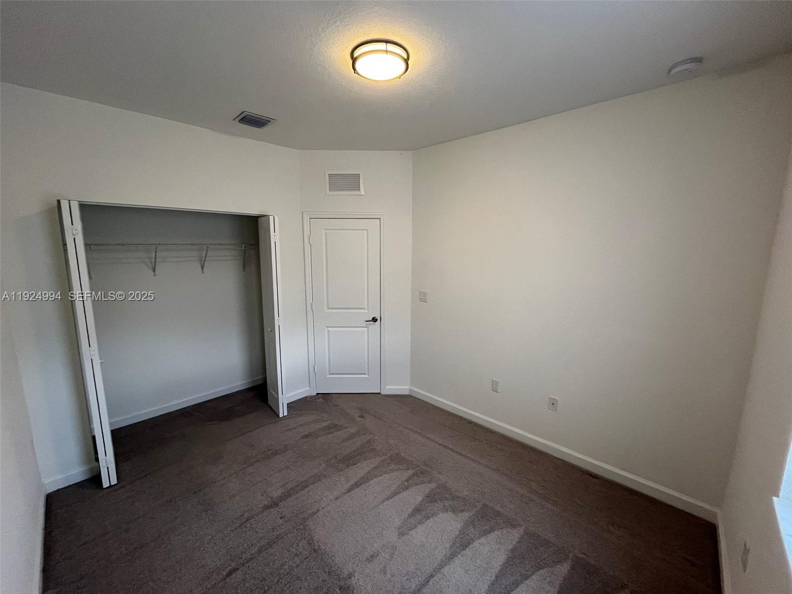 2602 Southeast 11th Street Homestead, FL 33035 - Photo 15 of 26 an empty room with a wooden door and mirror