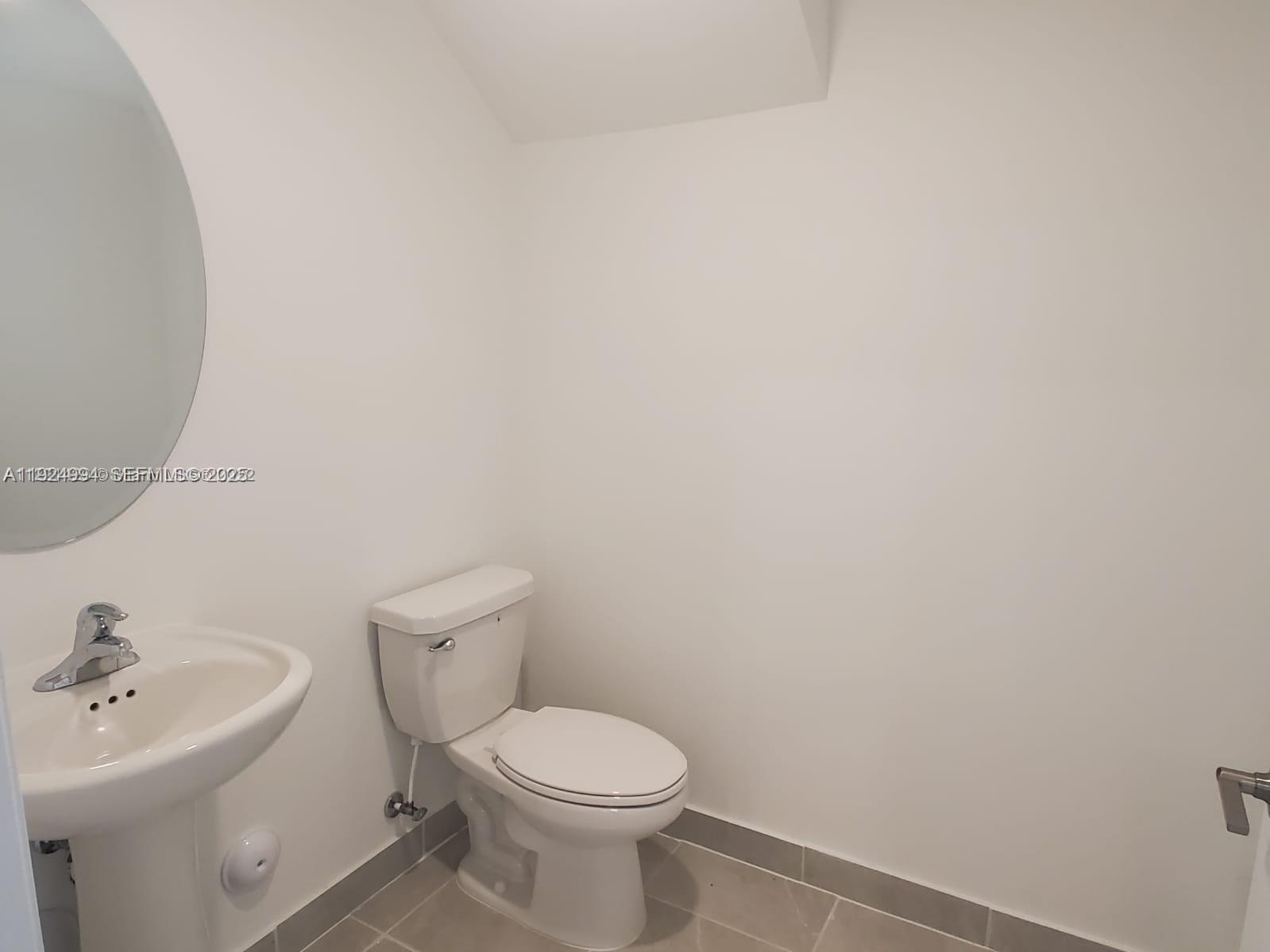 2602 Southeast 11th Street Homestead, FL 33035 - Photo 5 of 26 a white toilet sitting next to a white sink