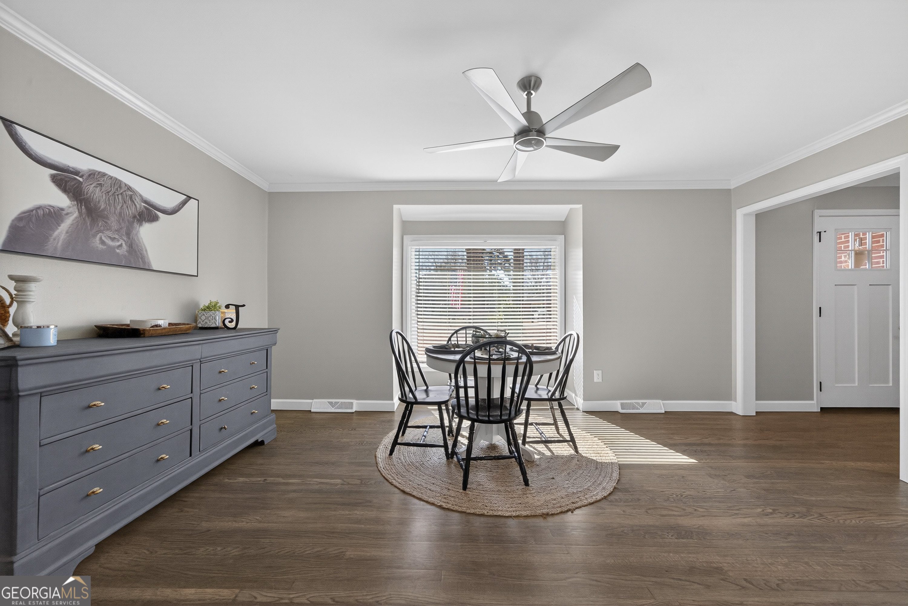 1739 Elmwood Road Milledgeville, GA 31061 - Photo 19 of 41 a dining room with wooden floor a chandelier fan a wooden table and chairs