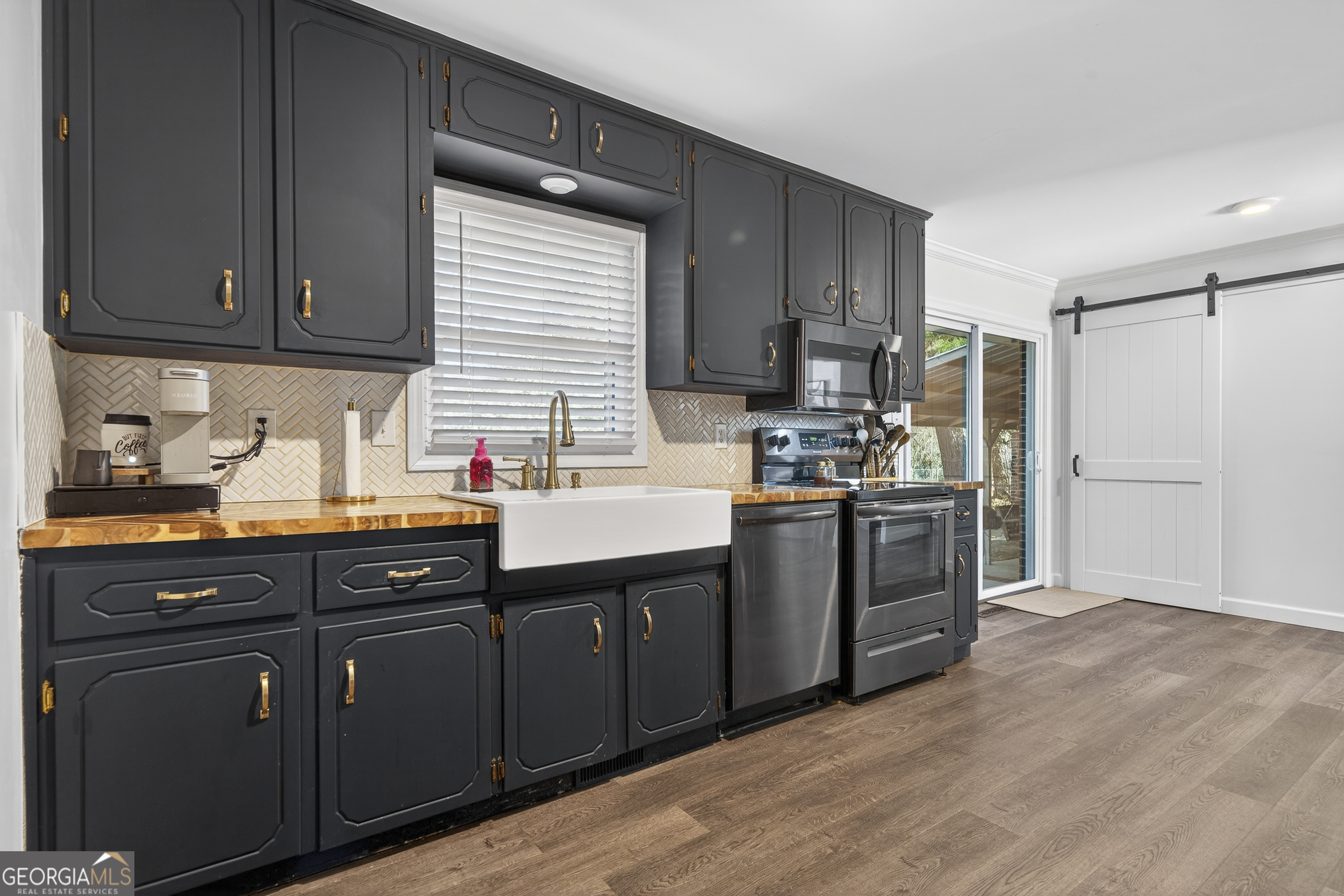 1739 Elmwood Road Milledgeville, GA 31061 - Photo 28 of 41 a kitchen with kitchen island granite countertop wooden cabinets a sink a stove a refrigerator and dishwasher with wooden floor