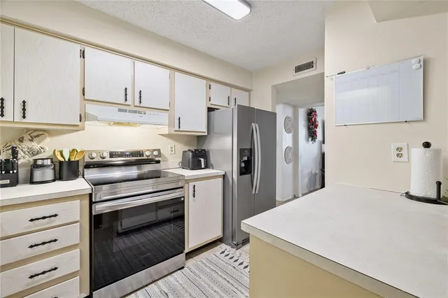 a kitchen with a white stove refrigerator and cabinets