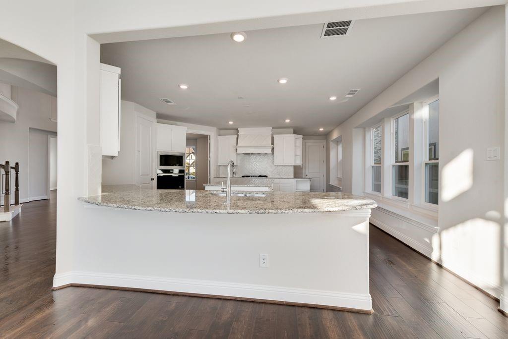 2438 Meridian Place Midlothian, TX 76065 - Photo 16 of 37 a large kitchen with stainless steel appliances lots of counter space and a wooden floor