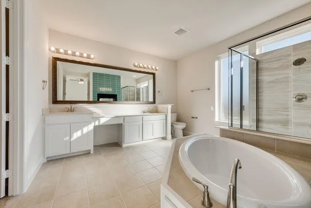 a spacious bathroom with a double vanity sink a mirror and a bathtub
