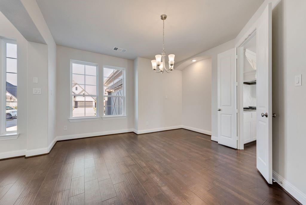 2438 Meridian Place Midlothian, TX 76065 - Photo 3 of 37 an empty room with wooden floor chandelier and windows