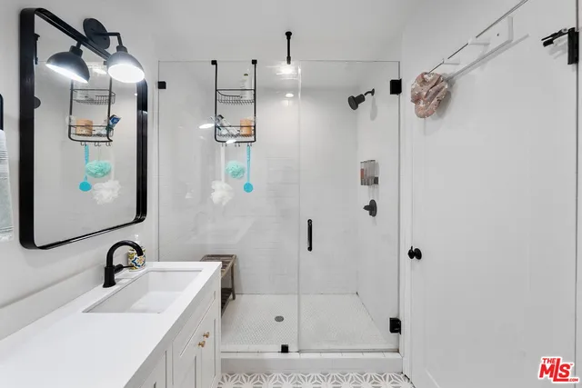 a bathroom with a shower sink and mirror