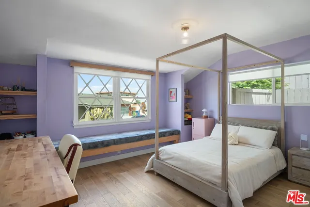 a bedroom with a bed and a painting on the wall