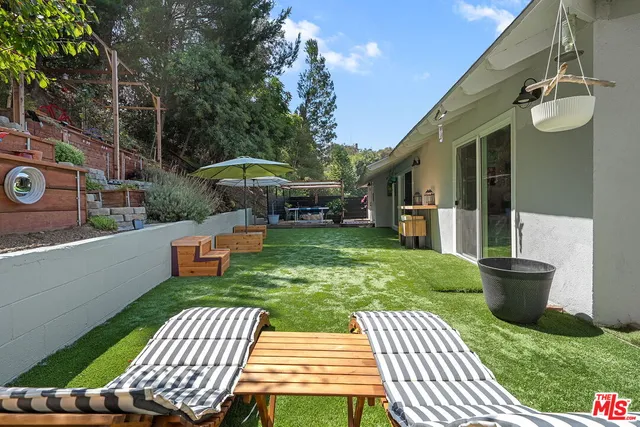 a view of a patio with chair and tables back yard of the house