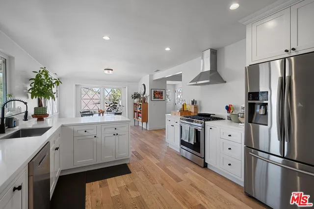a kitchen with stainless steel appliances white cabinets and wooden floors