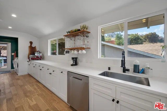 a kitchen with granite countertop a sink window and cabinets