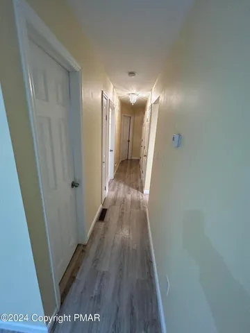 a view of a hallway with wooden floor