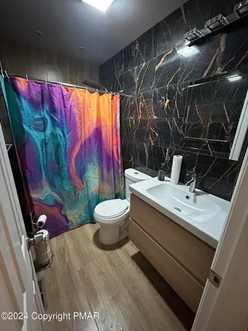 a bathroom with a toilet sink and shower curtain