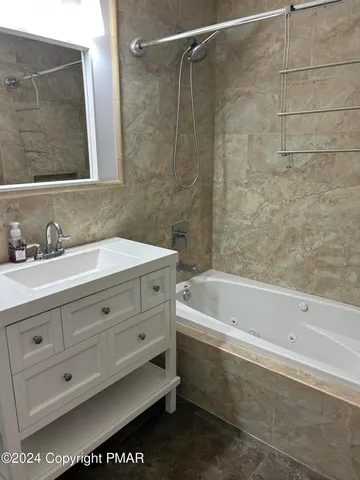 a bathroom with a bathtub a sink a vanity and a shower