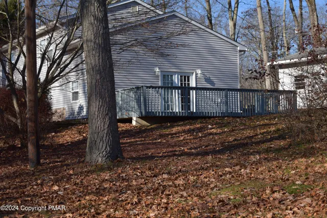 a view of a house with a yard and large tree