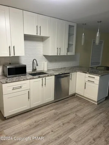 a kitchen with granite countertop a sink and cabinets