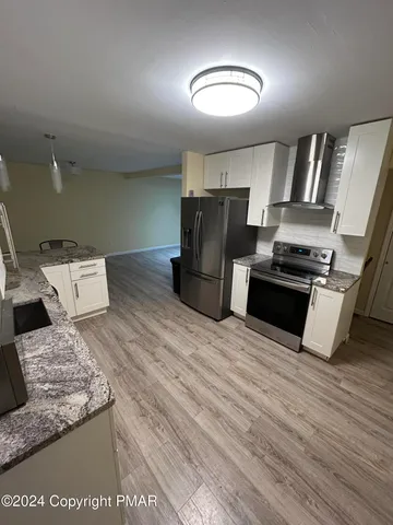 a kitchen with stainless steel appliances granite countertop a refrigerator and a stove