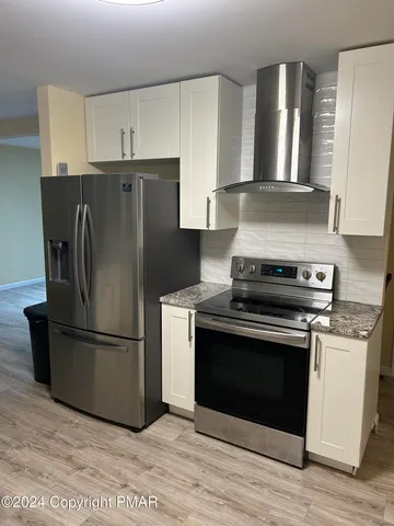 a kitchen with a stove refrigerator and microwave