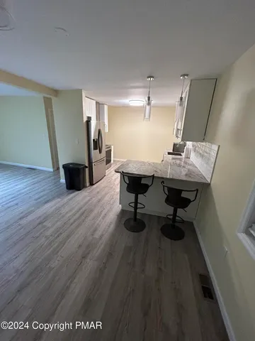 a workspace room with wooden floor table and chairs