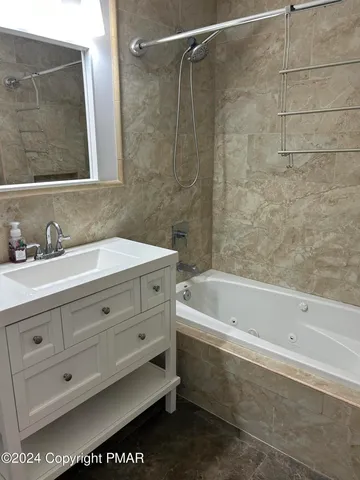 a bathroom with a bathtub a sink a vanity and a shower
