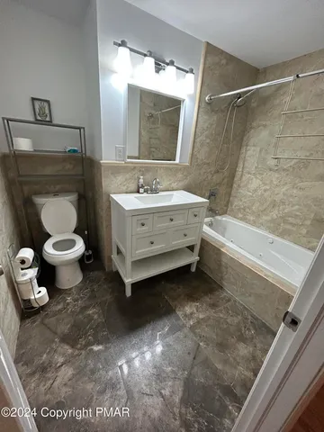 a bathroom with a sink toilet a mirror and bathtub