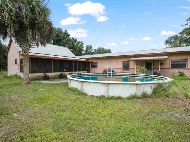 a view of a house with a yard balcony and swimming pool