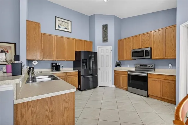 a kitchen with a sink a stove top oven a refrigerator and a sink