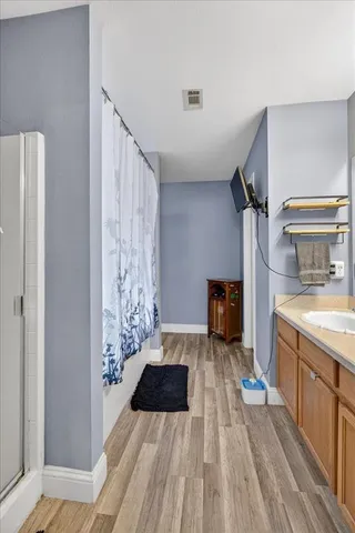 a kitchen with a sink and wooden floor