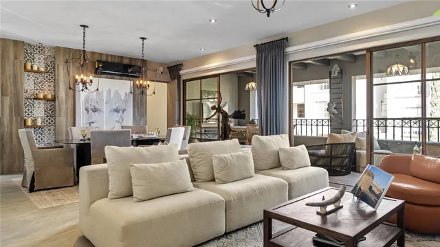 a living room with furniture a fireplace and a chandelier