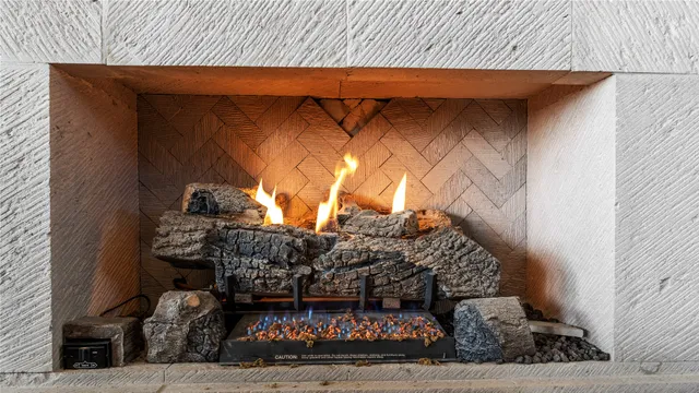 a work place with stainless steel appliances kitchen island granite countertop a table chairs and a refrigerator