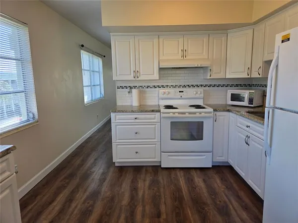 a kitchen with a refrigerator sink and cabinets