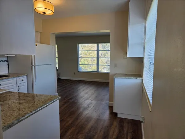 an empty room with wooden floor & closet area