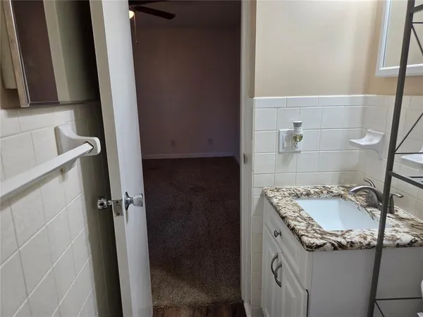 a bathroom with a granite countertop toilet and a shower