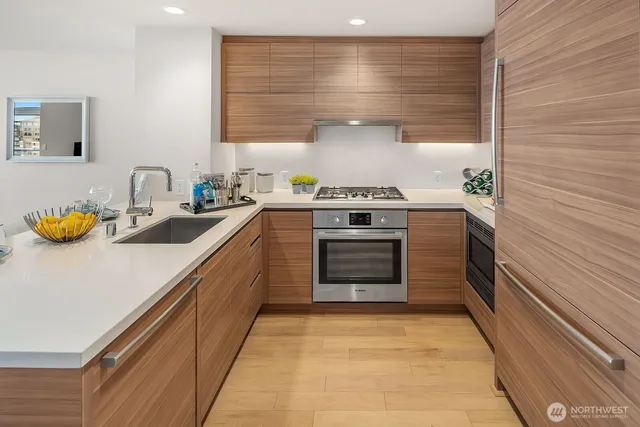 a kitchen with stainless steel appliances a stove and white cabinets