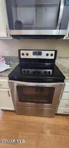 a stove top oven sitting inside of a kitchen