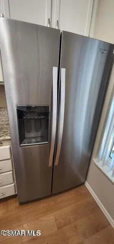 an empty room with wooden floor and entrance