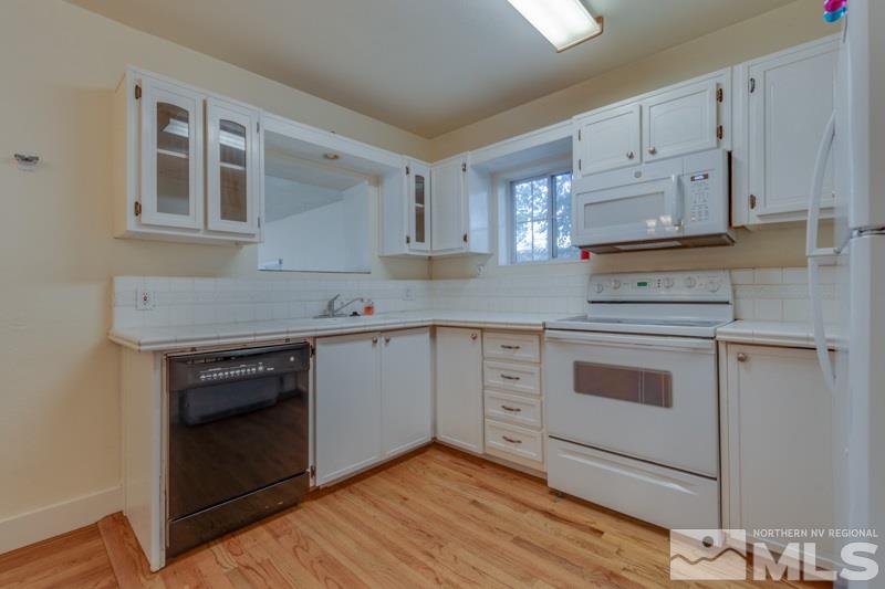 608 Cheney Street Reno, NV 89502 - Photo 7 of 22 a kitchen with granite countertop white cabinets and white appliances
