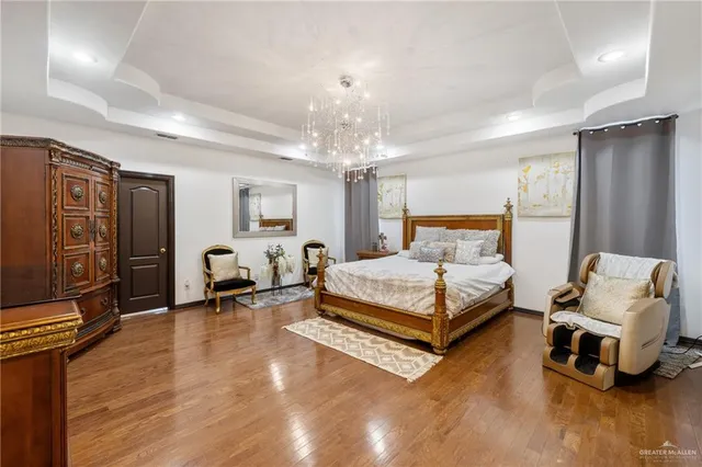 a bedroom with a bed and a chandelier